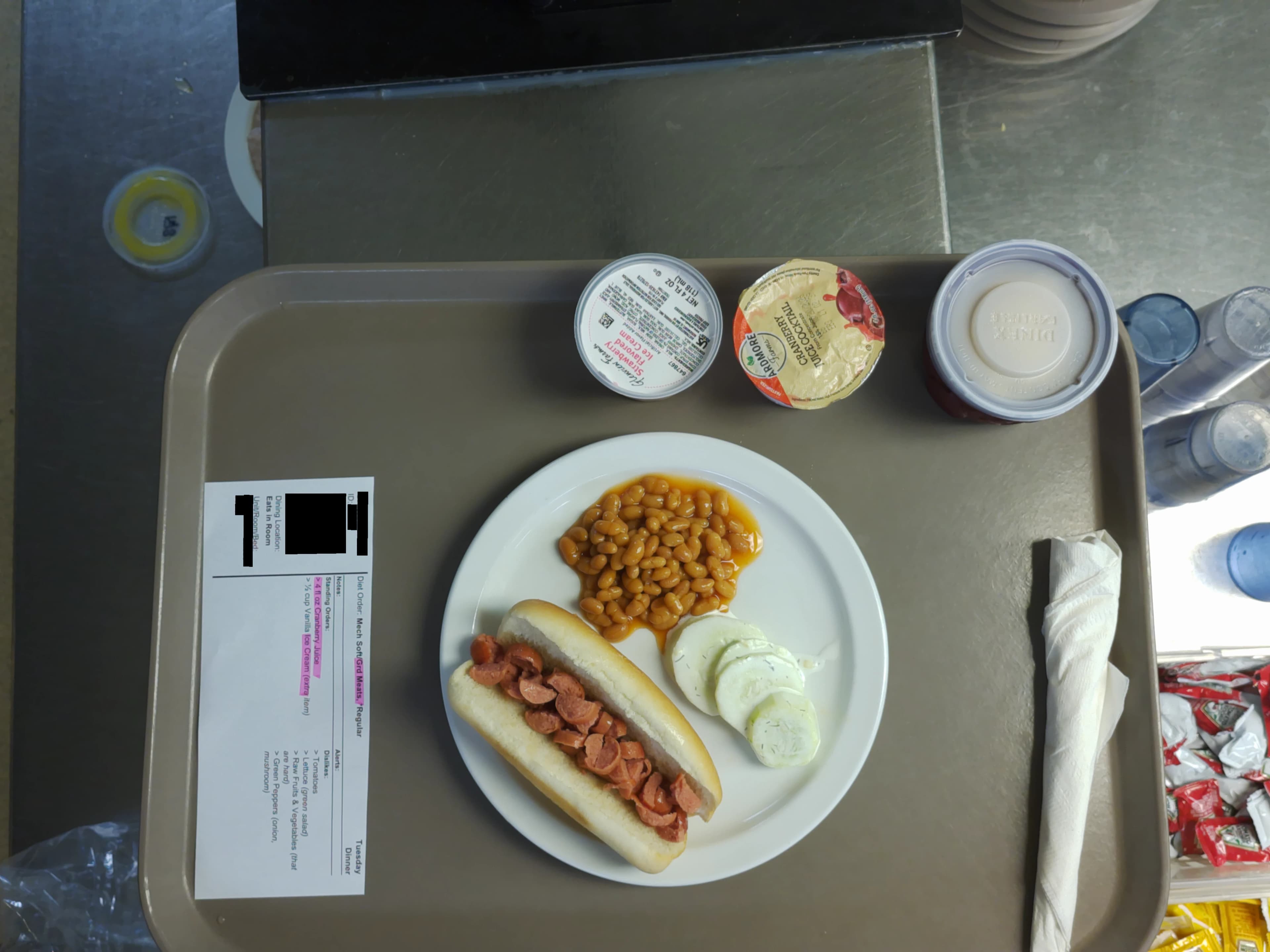 Tray photo: modified-texture ticket, chopped hot dog in a whole bun, and cucumber.